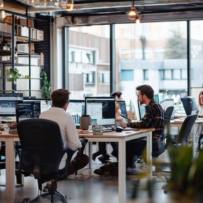A digital marketing agencys office with employees working on computers, discussing strategies, and analyzing data